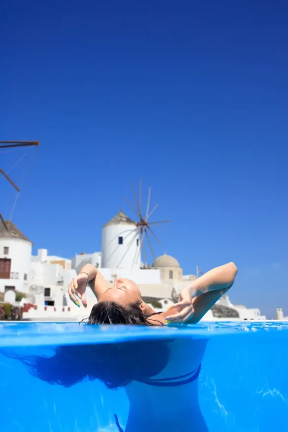 woman in water with a view over Santorini