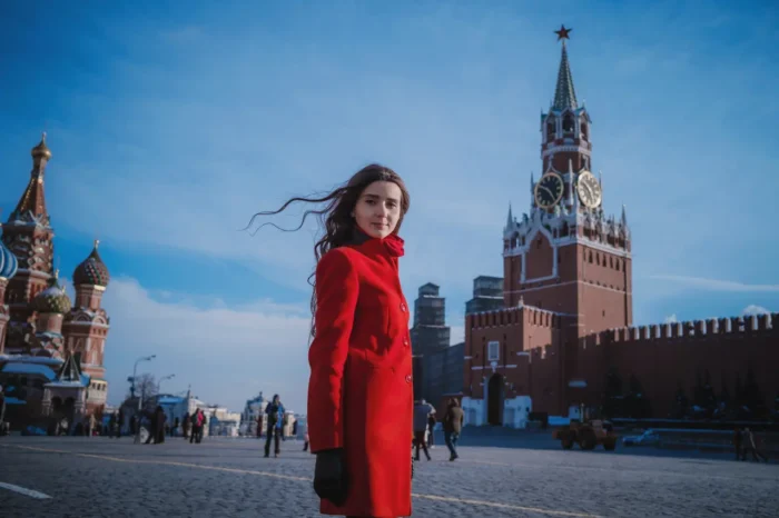 Russian Woman in red coat walking the Red Square in Moscow